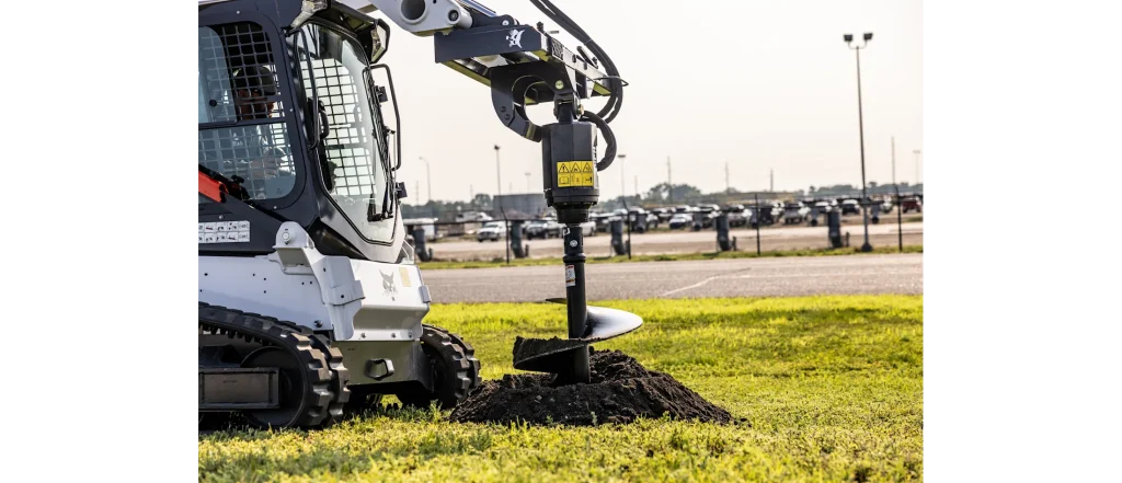 Compact track loader with auger attachment for post-hole digging and fencing site prep in Roseburg, Oregon.